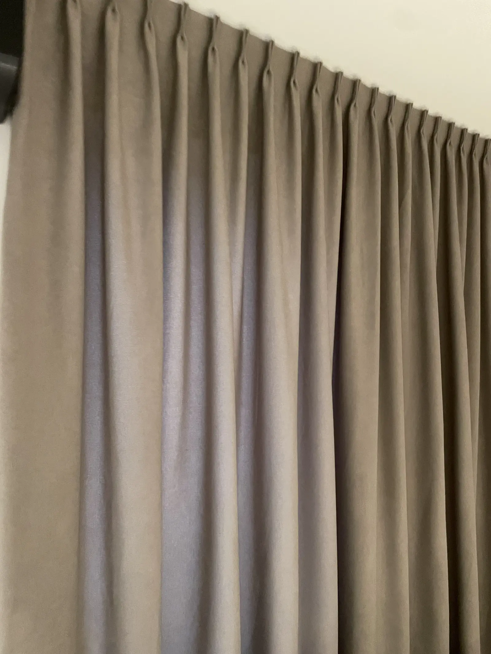 Detal zawieszenia zasłon na czarnej szynie sufitowej — zbliżenie